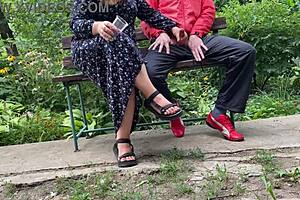 The hot milf jerks off the monster cock into a glass in the park on the bench