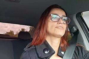Redhead talks dirty while giving blowjob in car on the street.