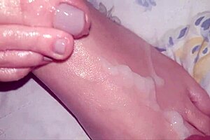 Redhead gives blowjob and foot handjob.